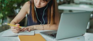 woman in blue tank top using macbook pro