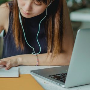 woman in blue tank top using macbook pro