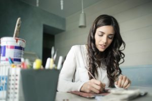 woman sitting while holding pen