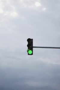 green traffic light under white clouds