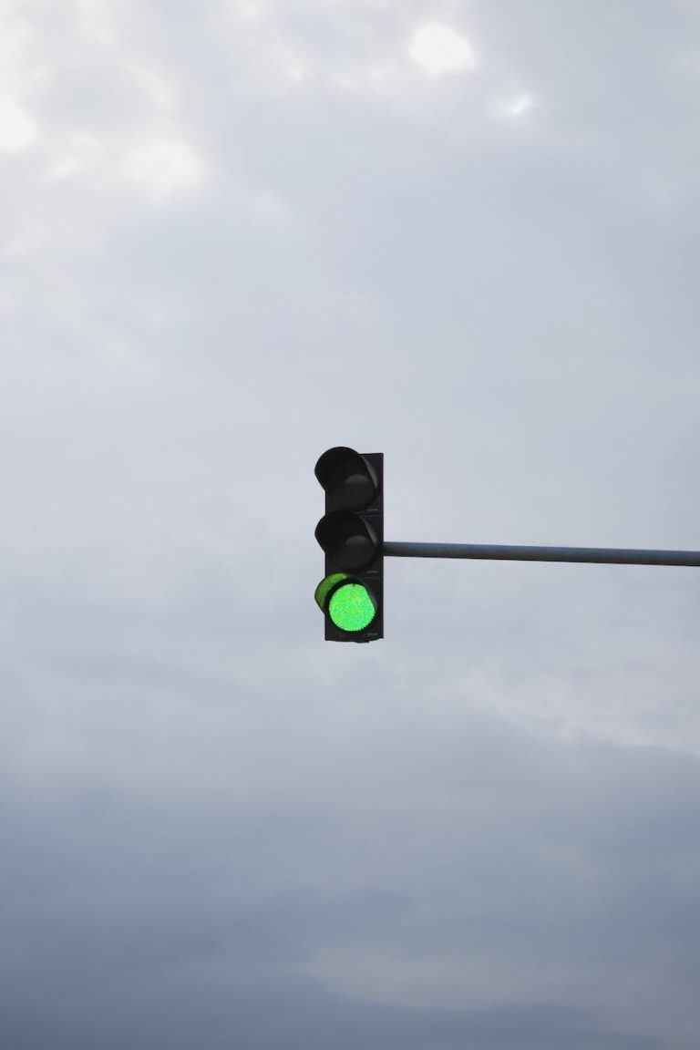 green traffic light under white clouds